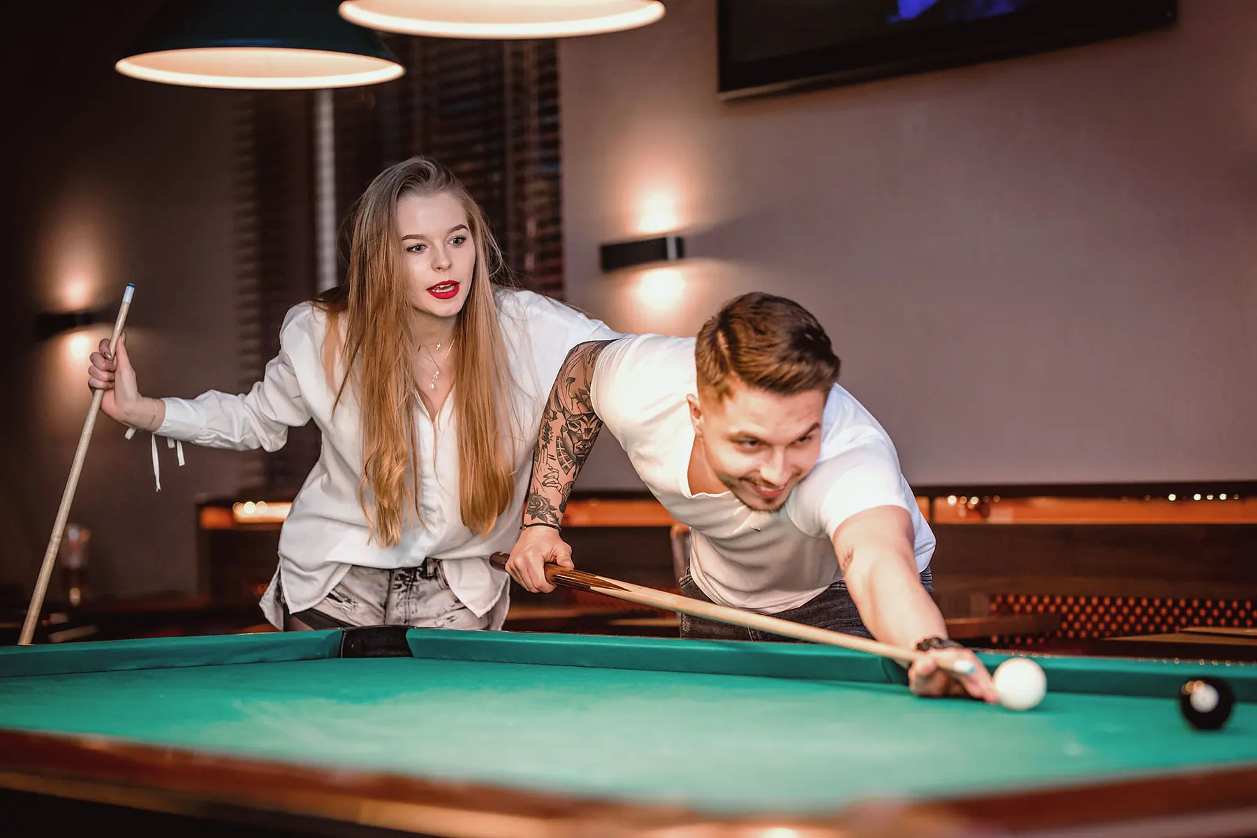 Dwoje gości przy stole bilardowym pool w Klubie Pictures