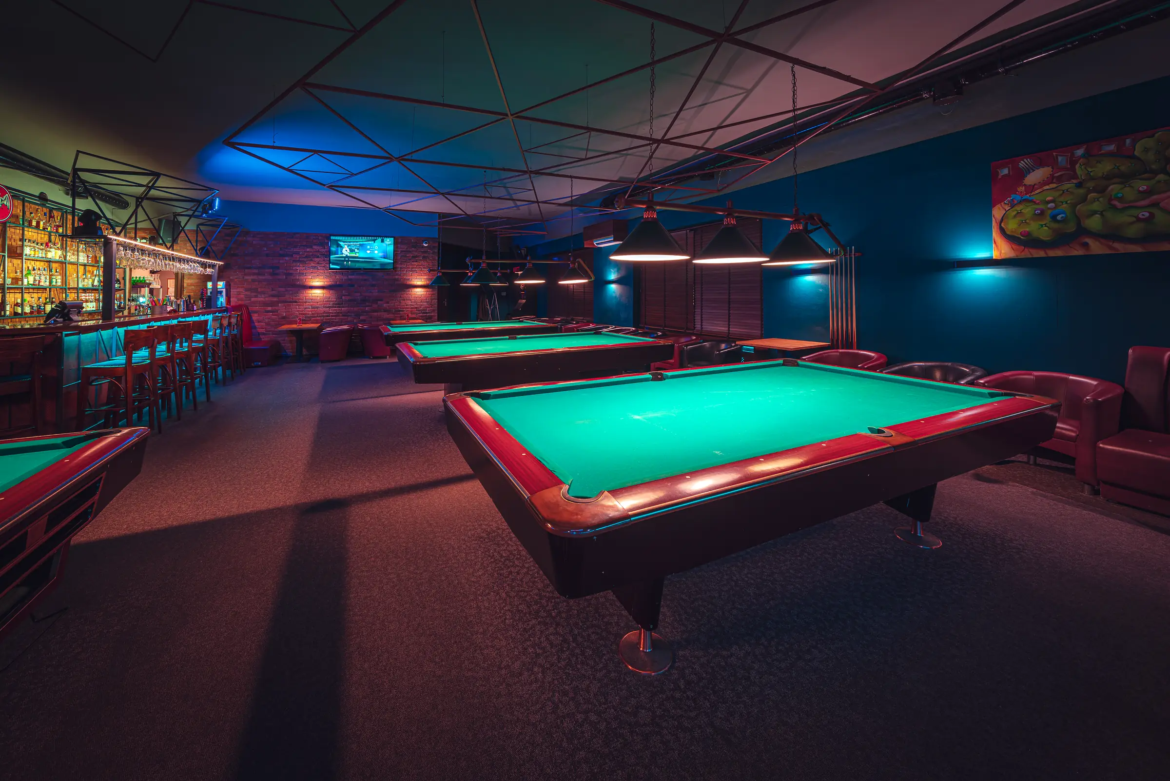 The main room at Klub Pictures: pool tables under lamps, the dartboard and the bar